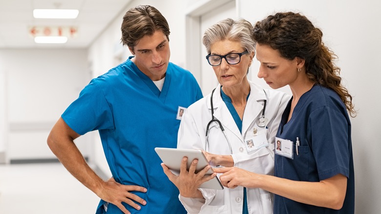 doctors discussing around a computer tablet