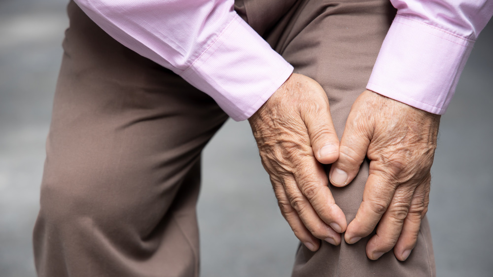 man holding knee, arthritis pain