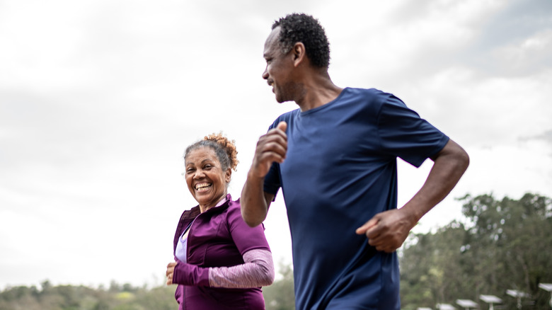 mature couple jogging near water