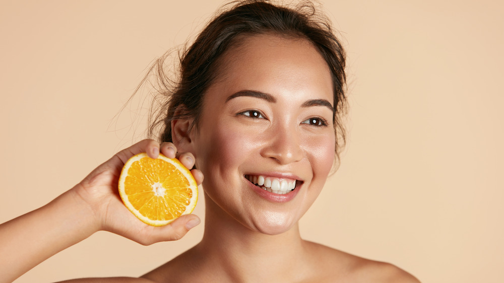 Smiling girl holding orange