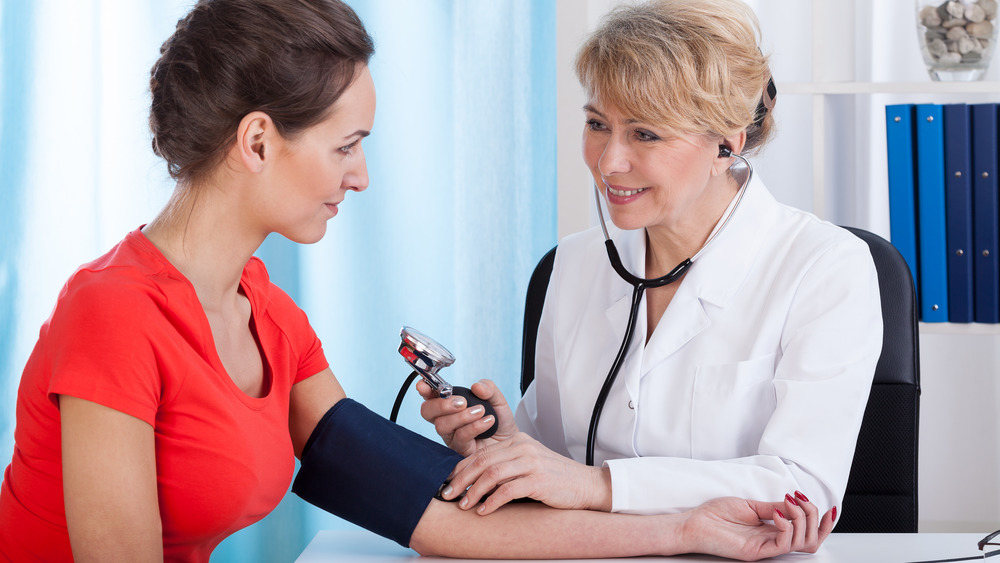 doctor measuring woman's blood pressure