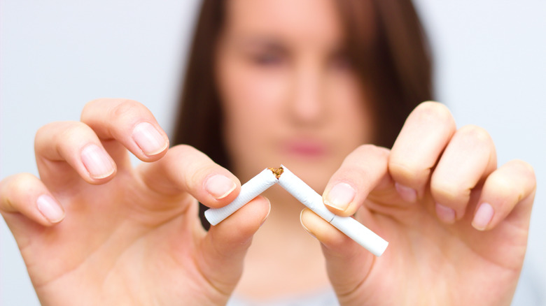 woman breaking apart a cigarette