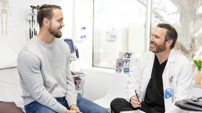 Man smiling while talking to his doctor