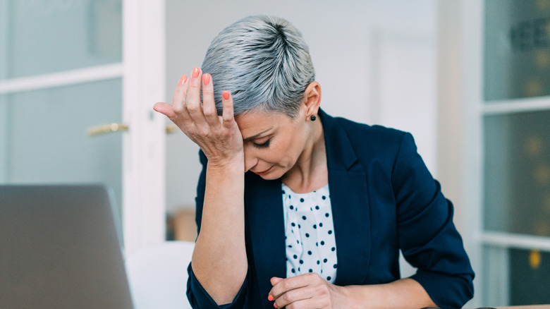 Woman with headache at desk