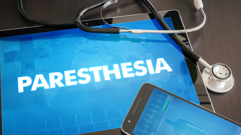 A phone and a stethoscope over a tablet with the word "paresthesia" on it 