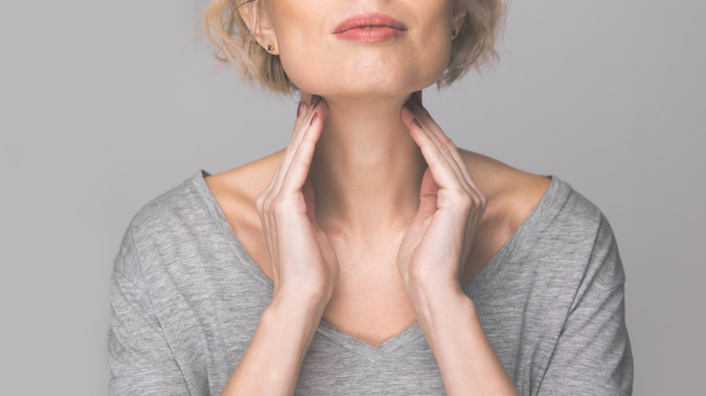 Woman checking her thyroid gland