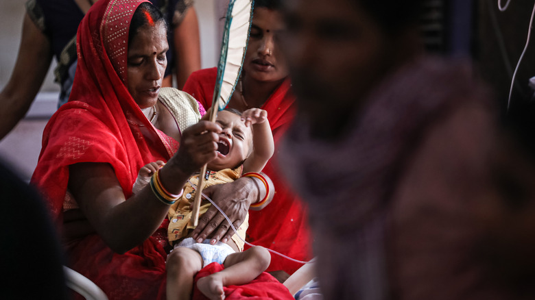 Indian Woman Fanning Baby with GI Discomfort