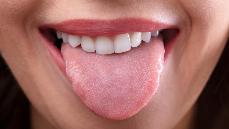 Close up of a woman's mouth as she sticks out her tongue