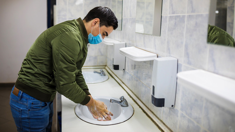 Man wearing mask and washing hands