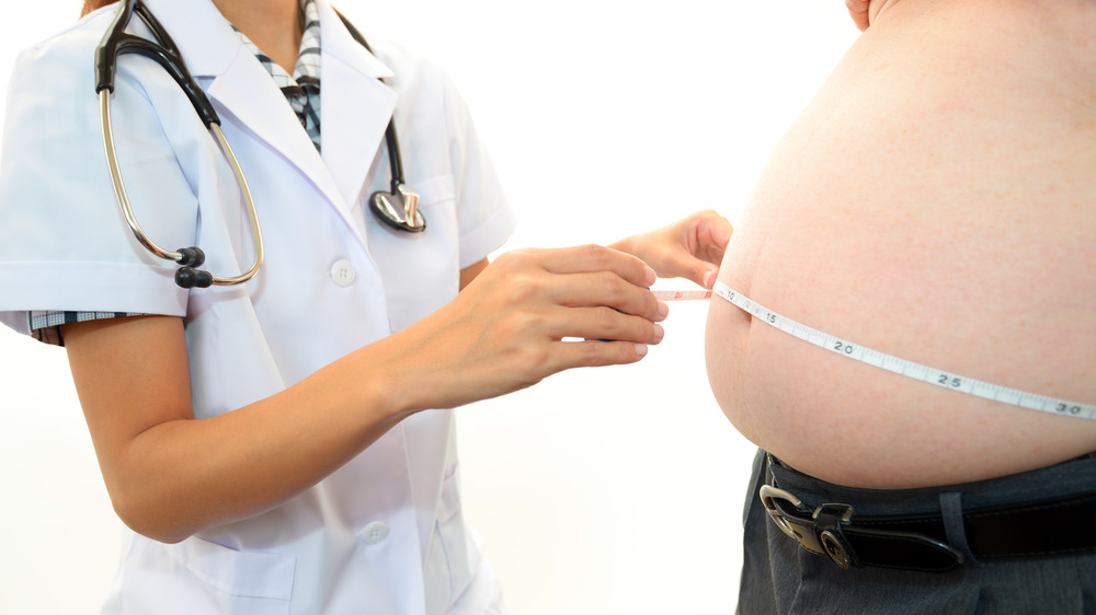 Doctor measuring patient's big belly