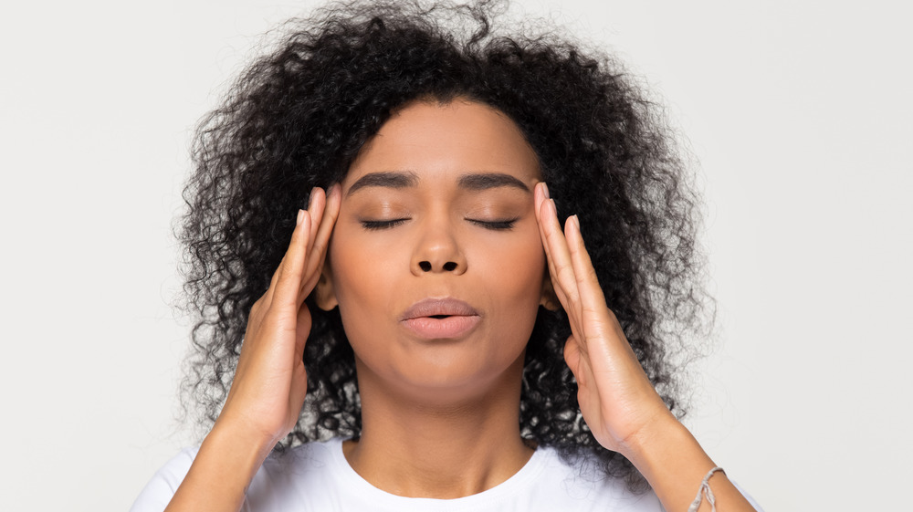 Woman with headache holding her head