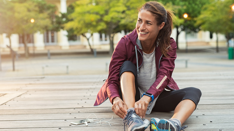 Smiling woman tying sneakers