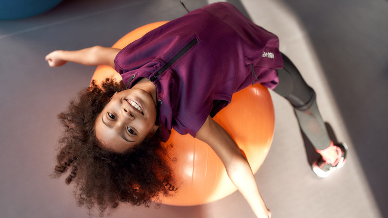 A woman lying back on an exercise ball